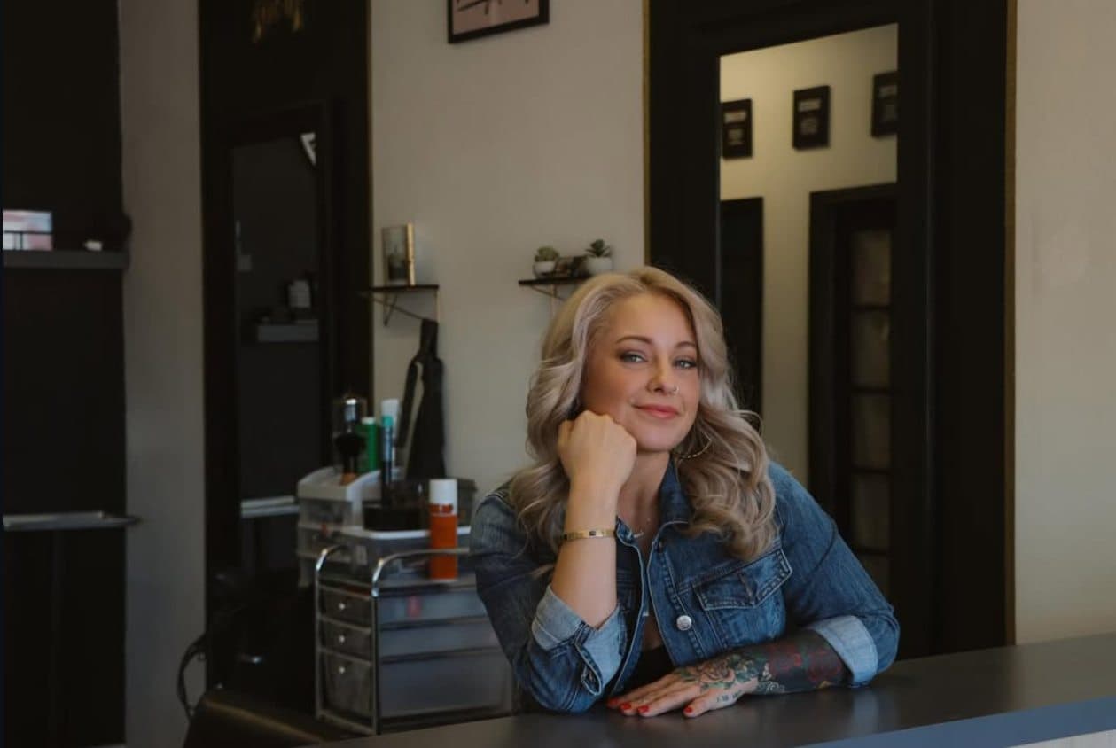 Shanna, the artist and owner of Ever North Beauty, resting her chin on her hand at the studio counter